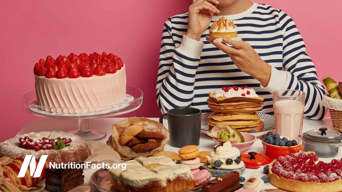woman sitting at table full of desserts