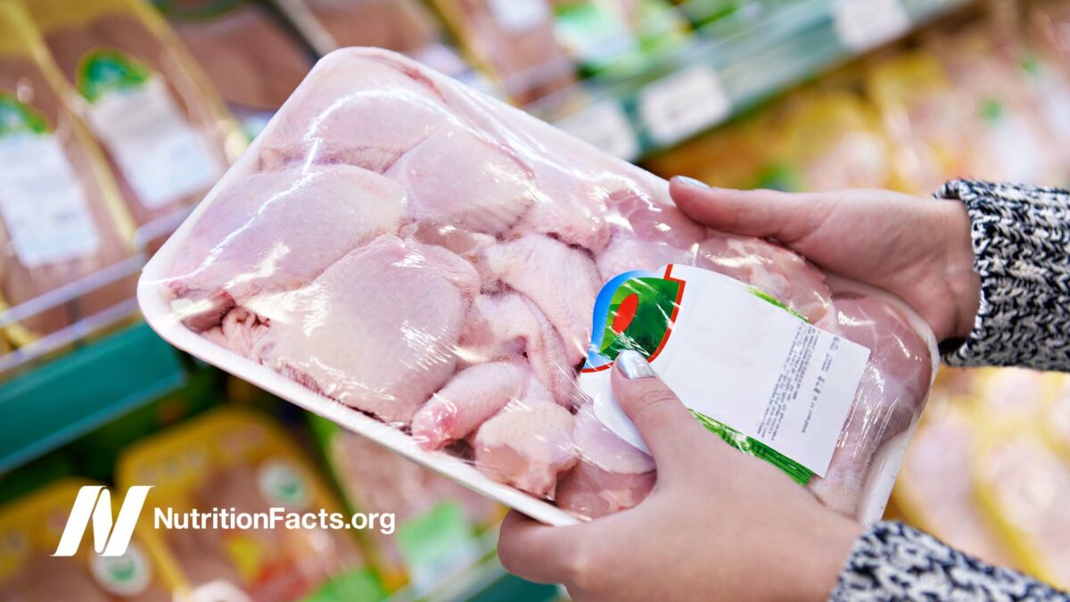 woman's hands holding package of chicken