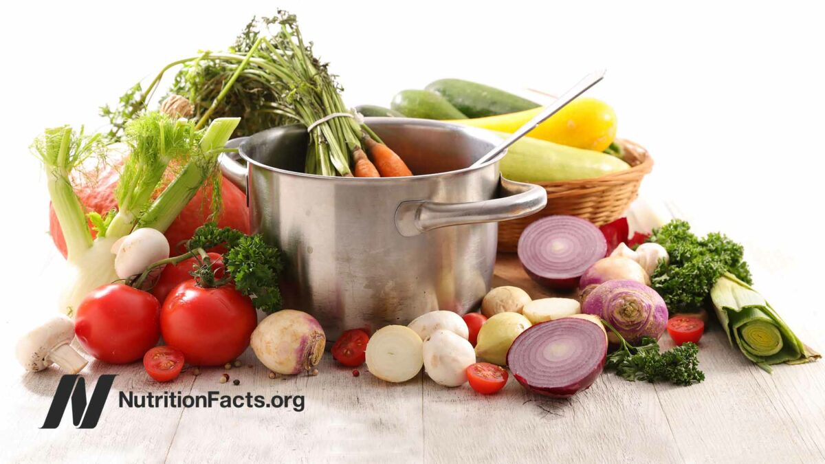 variety of raw veggies around a cooking pot