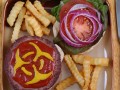 plate of fries and a burger with mustard in the shape of a hazard sign