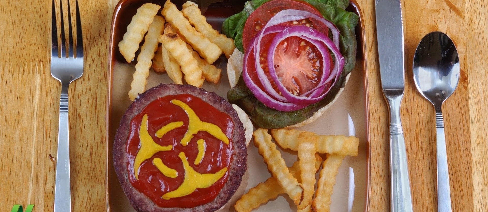 plate of fries and a burger with mustard in the shape of a hazard sign