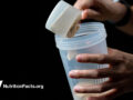 person putting protein powder into a cup