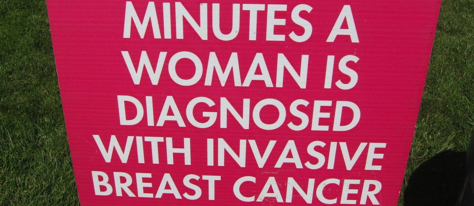 sign saying "minutes a woman is diagnosed with invasive breast cancer"