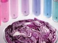 sliced purple cabbage in front of various test tubes with liquids of different colors