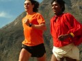 two people running with a mountain in the background