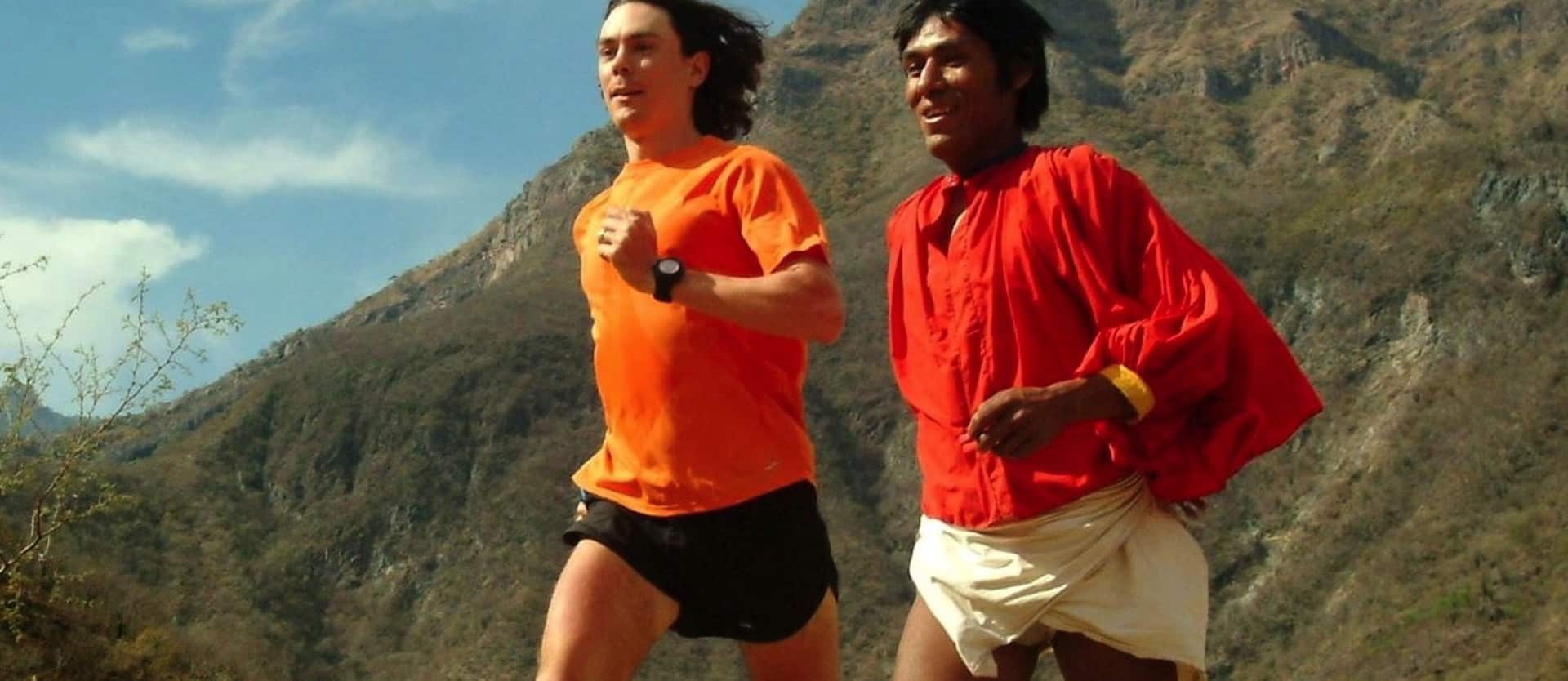 two people running with a mountain in the background