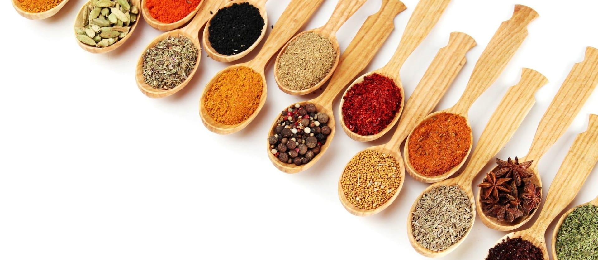 wooden spoons filled with various herbs and spices