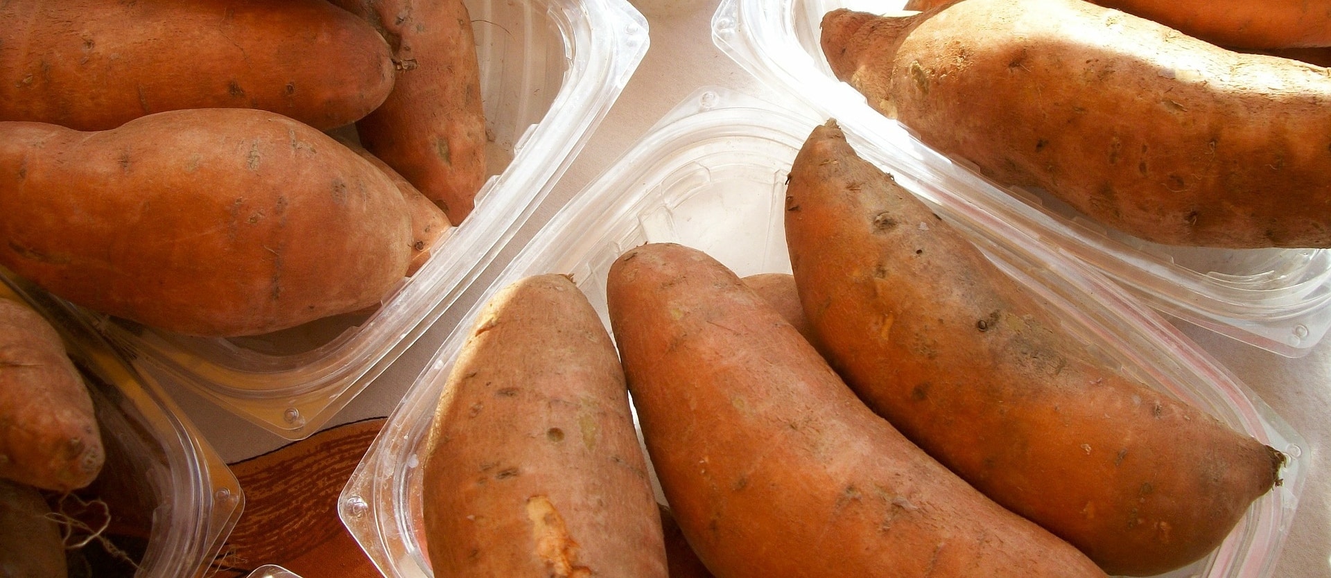 plastic containers filled with whole sweet potatoes