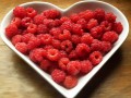 heart-shaped dish filled with raspberries