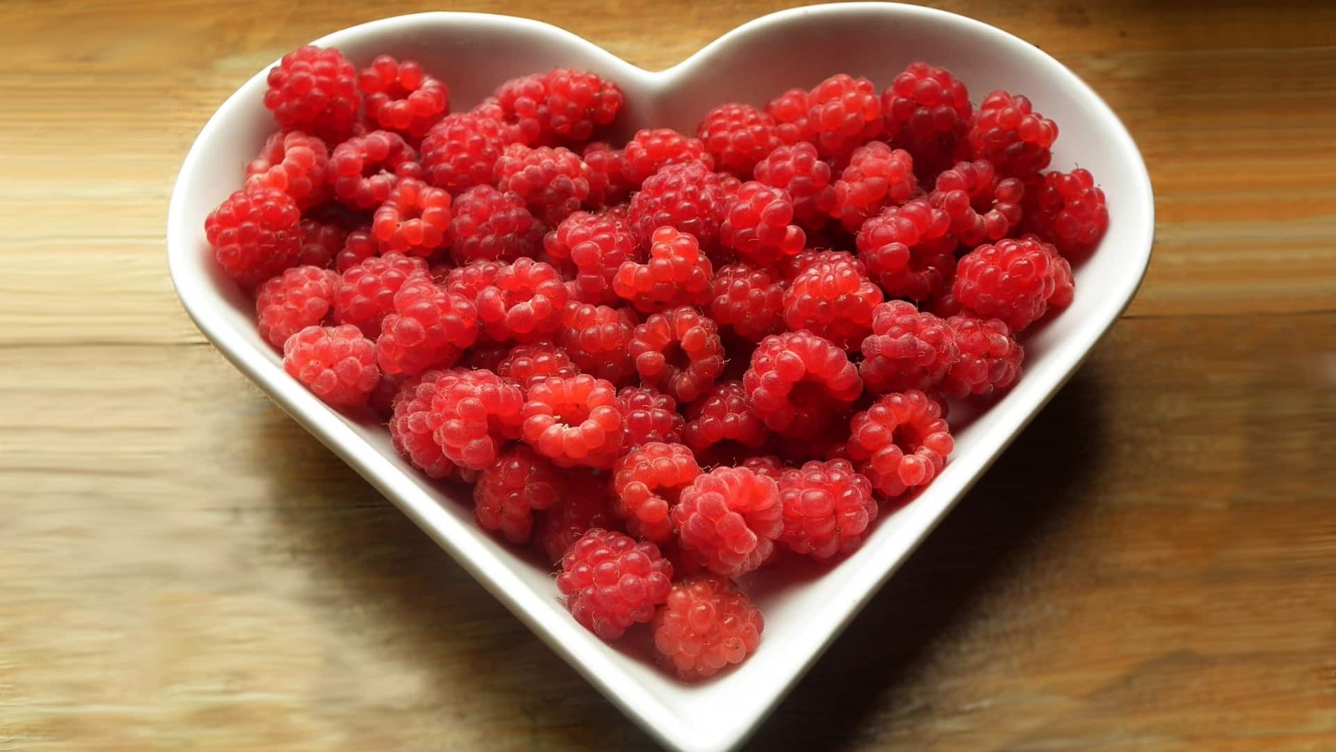 heart-shaped dish filled with raspberries