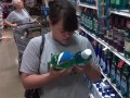 person in a shopping aisle comparing bottles of mouthwash