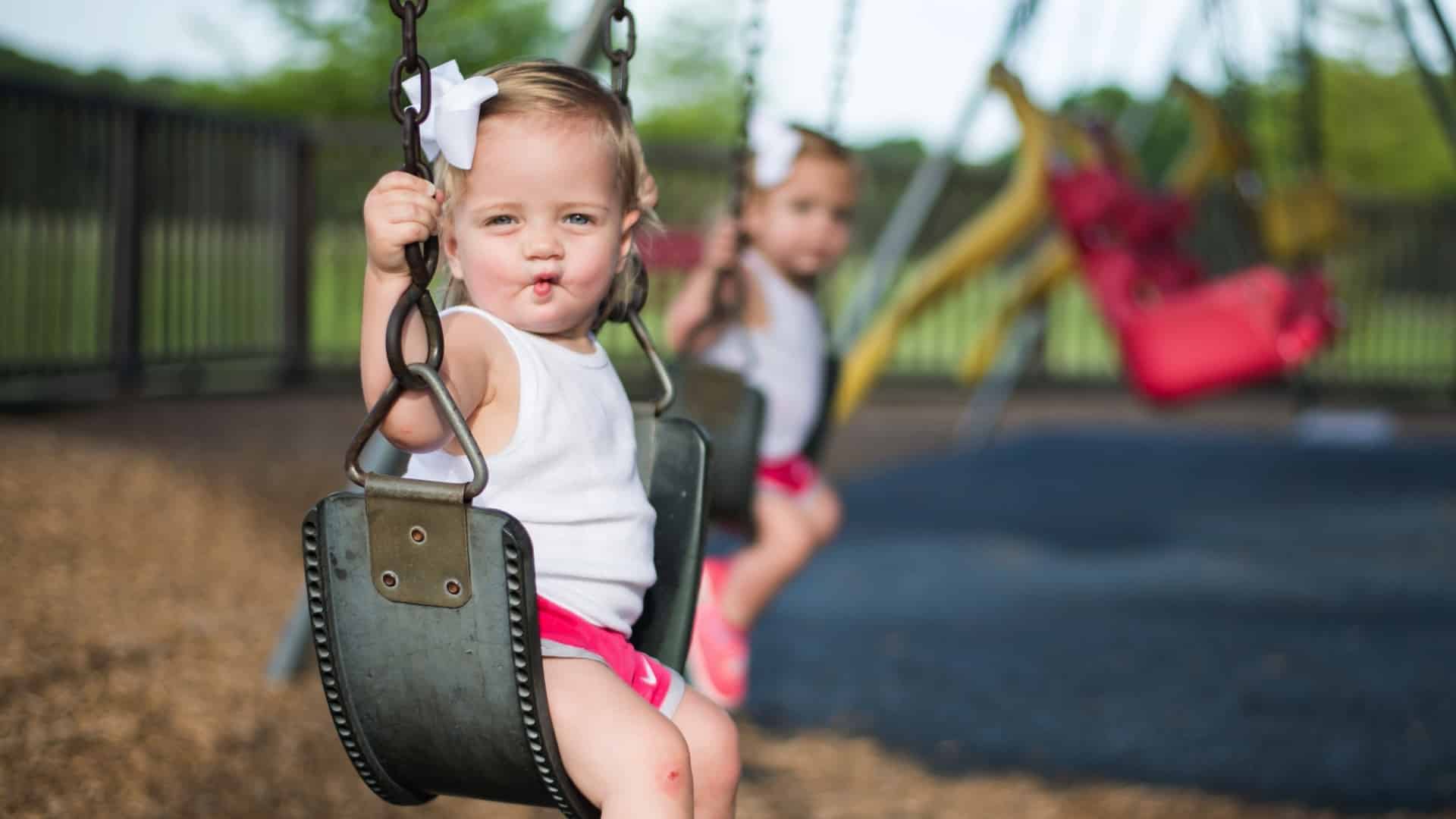 children sitting in swings