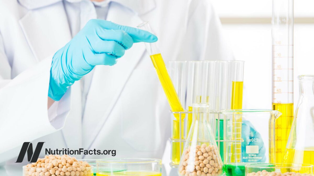 lab beakers filled with yellow chemicals and soy beans