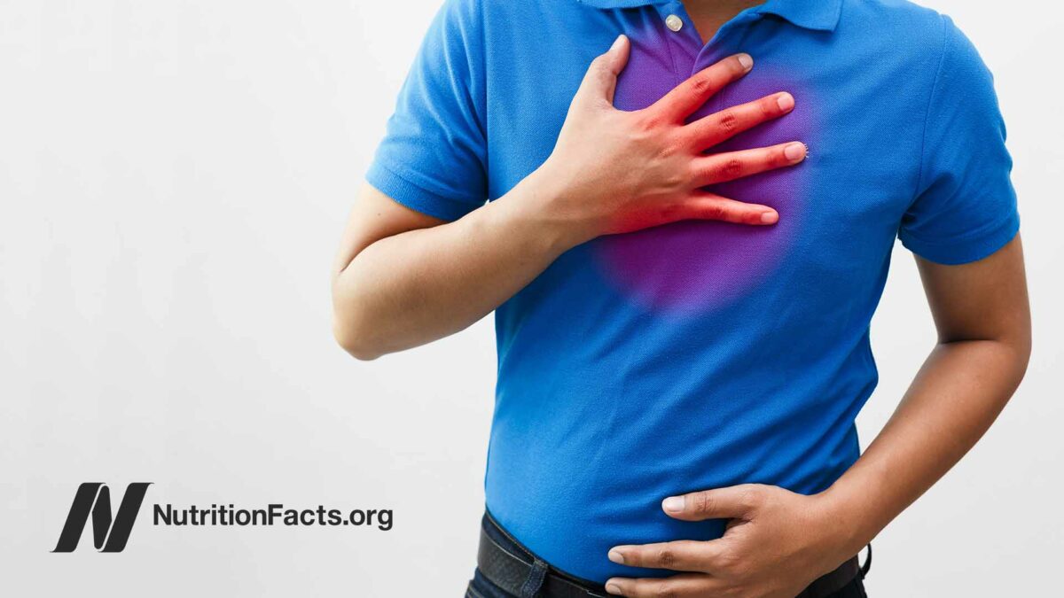 man in blue shirt with hand on chest