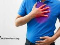 man in blue shirt with hand on chest