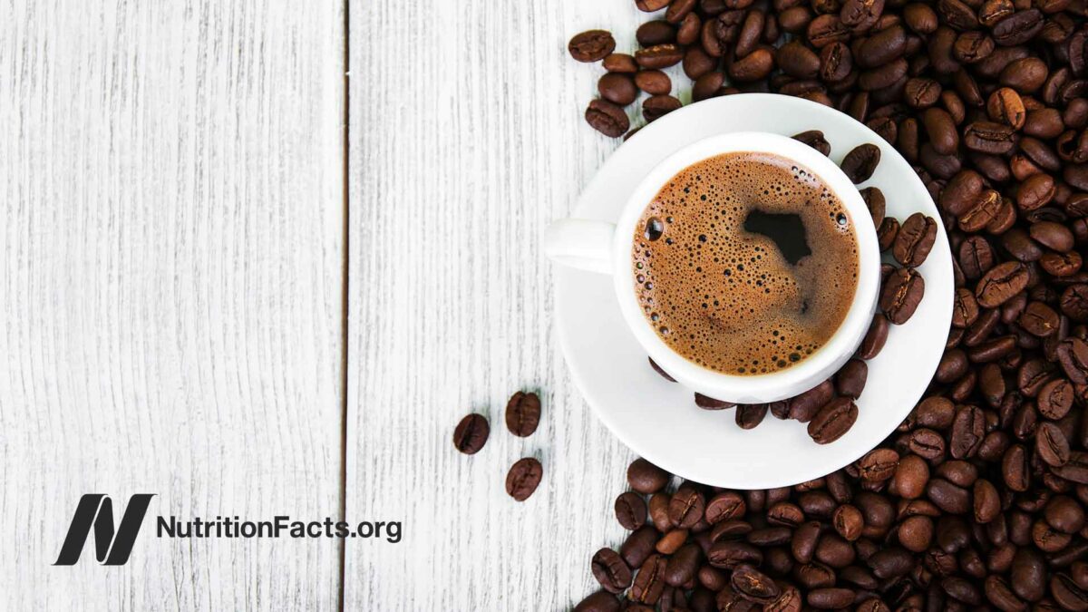 cup of brewed coffee and coffee beans on wooden table