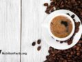 cup of brewed coffee and coffee beans on wooden table
