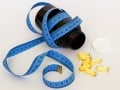 bottle of supplements with a tape measure wrapped around it