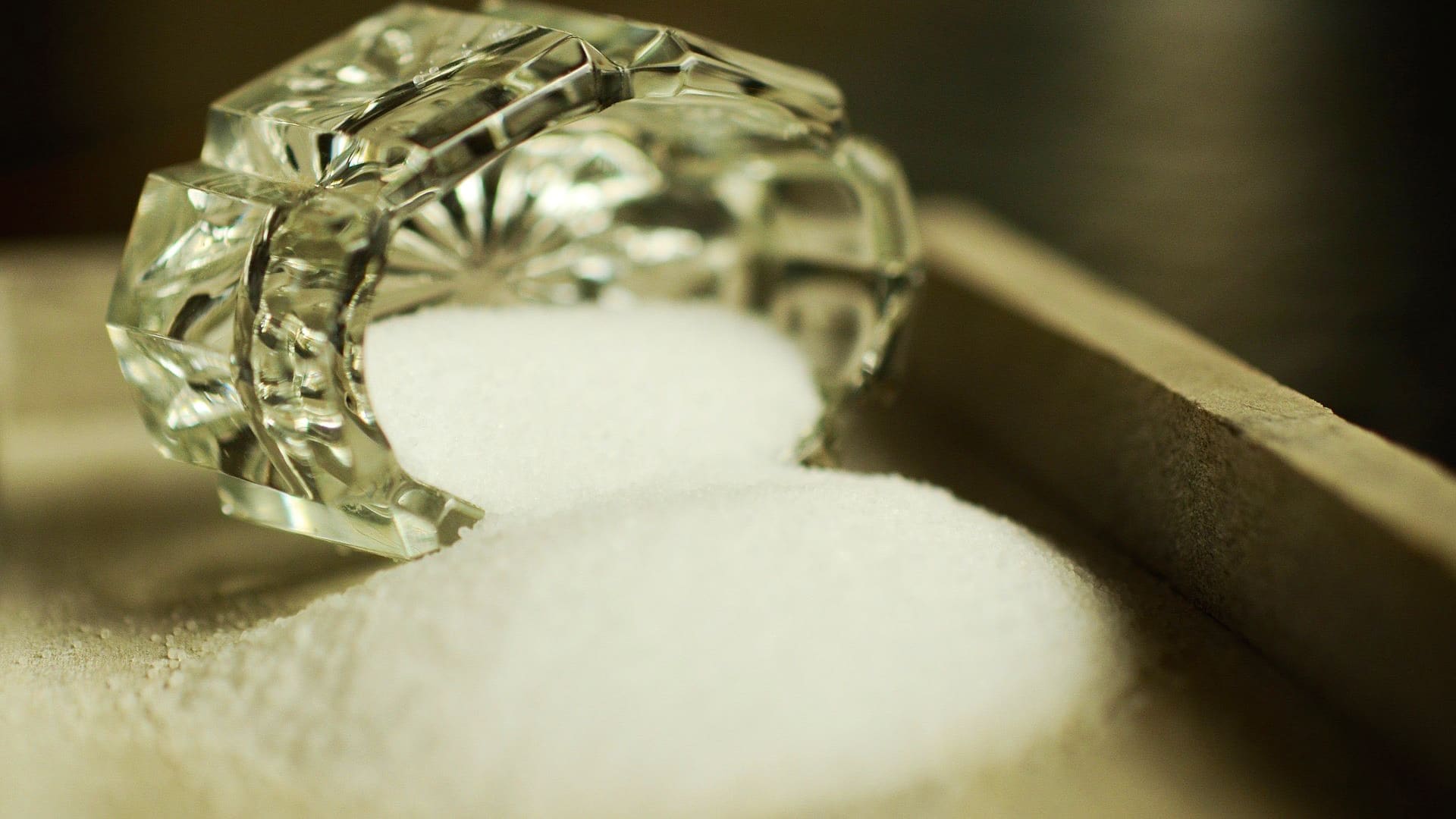 glass jar on its side with salt spilling out
