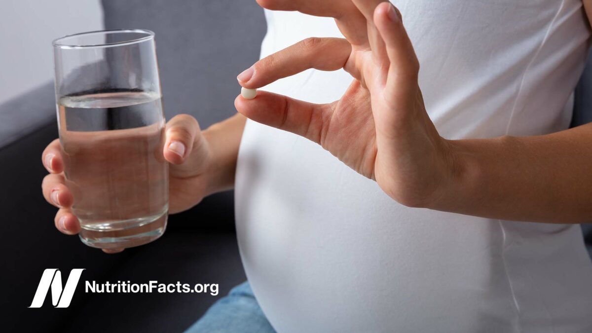 pregnant woman holding pill
