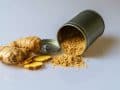 piece of fresh ginger root alongside a tub of ginger powder