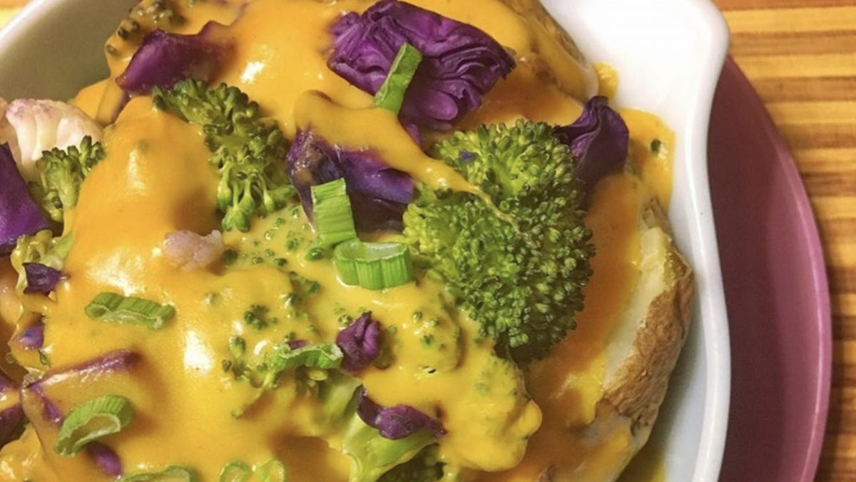 bowl of potatoes, cabbage, and broccoli covered in a sauce