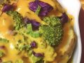 bowl of potatoes, cabbage, and broccoli covered in a sauce