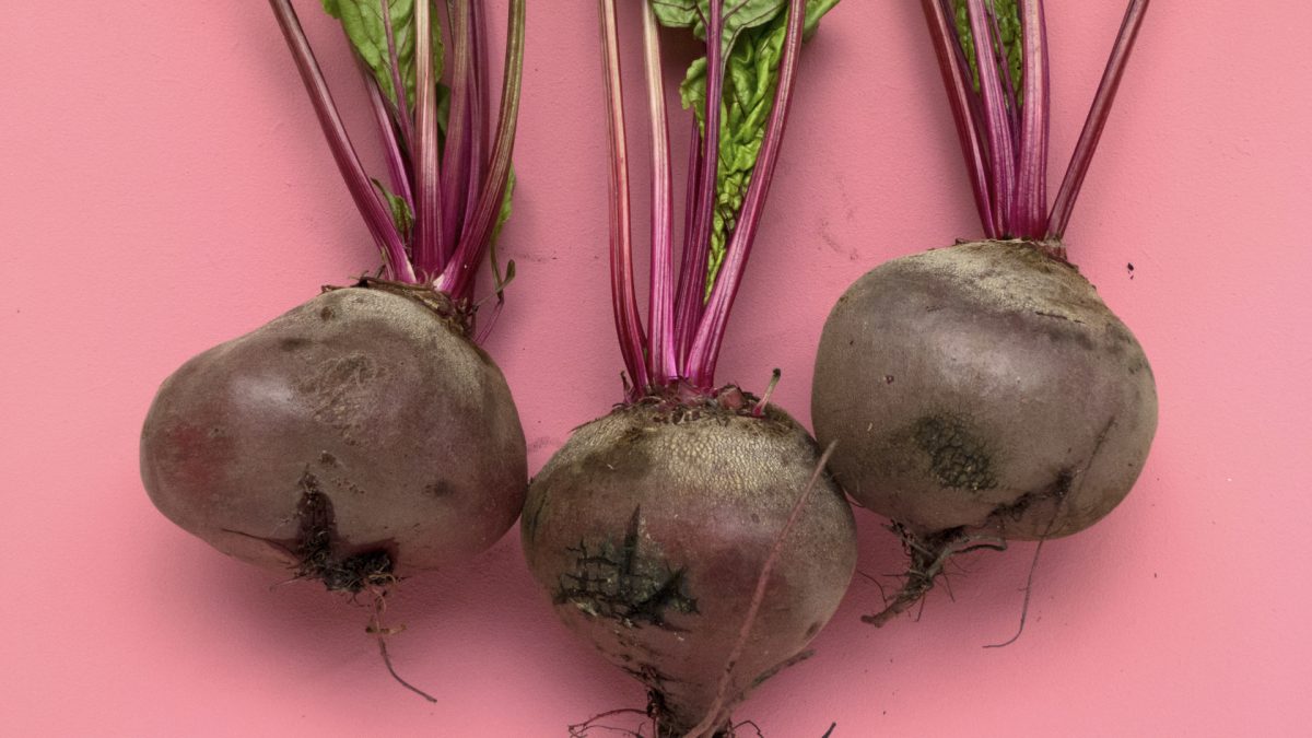 three beets on a pink background