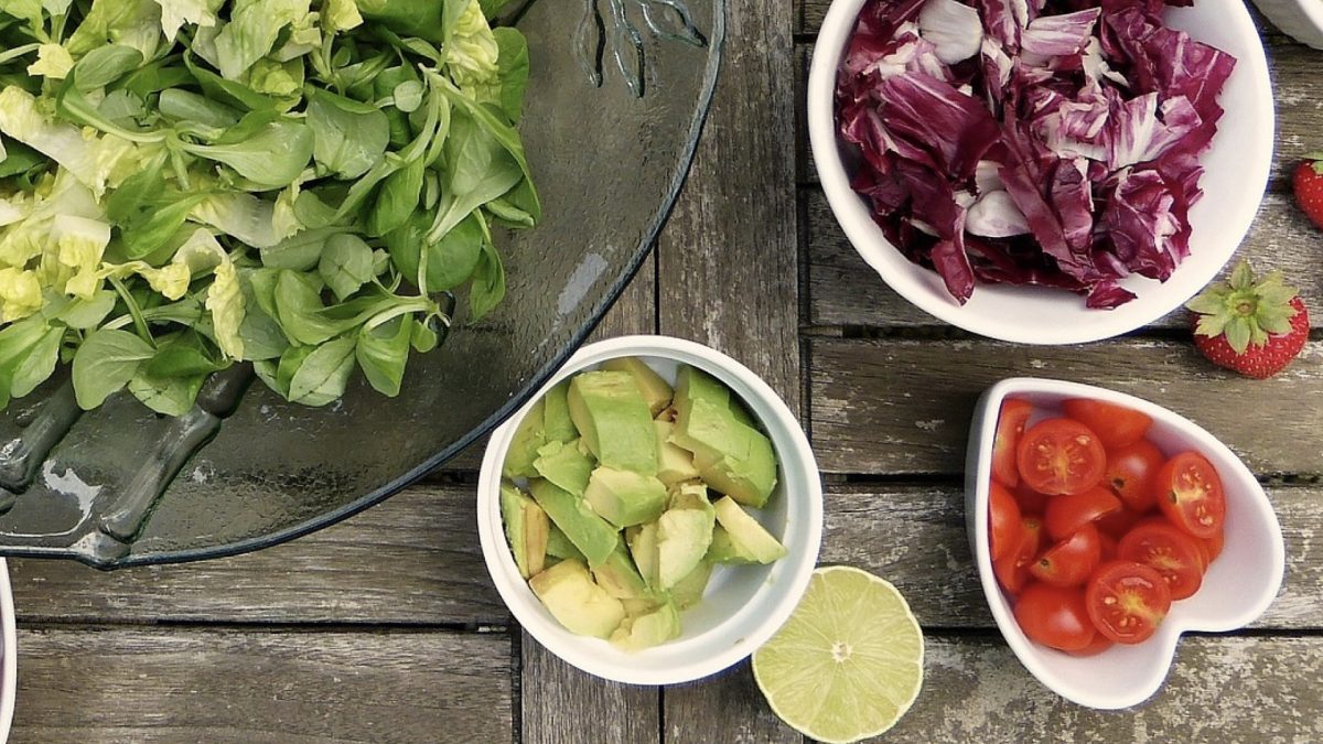 bowls of greens, diced avocado, tomatoes, and radicchio
