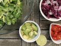 bowls of greens, diced avocado, tomatoes, and radicchio