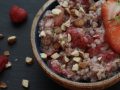 bowl of oatmeal topped with nuts and strawberries