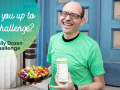 Dr. Greger holding a bowl of vegetables and a phone with the daily dozen app on it
