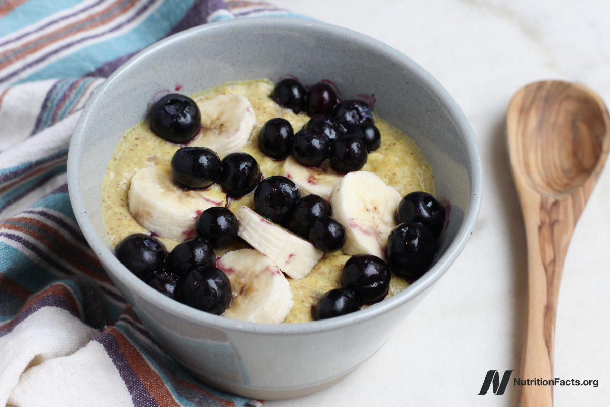bowl of cooked grains topped with sliced banana and blueberries