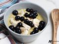 bowl of cooked grains topped with sliced banana and blueberries
