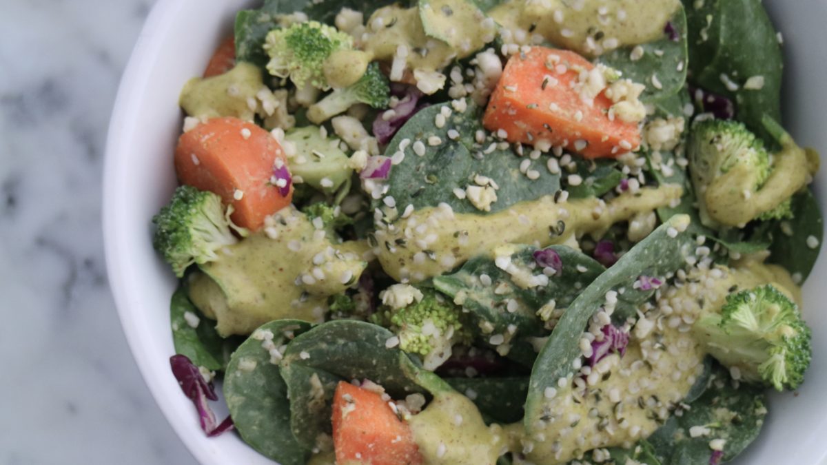 salad topped with caesar dressing and hemp seeds