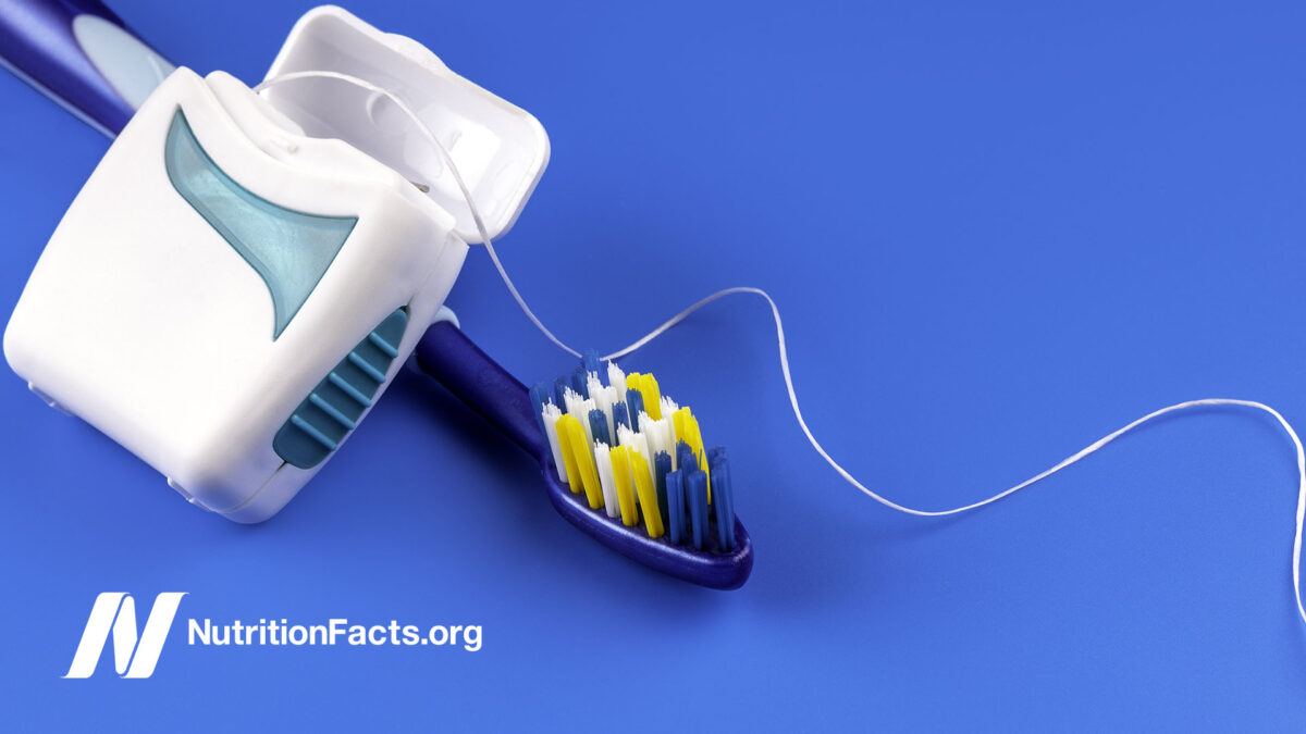 toothbrush and floss against blue background