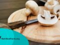 Fresh white mushrooms on a wooden background