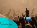 Hand raised showing a rock sign over the crowd at heavy metal concert