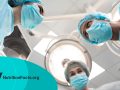 View of the operation room with three doctors in blue medical masks