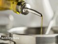 Cooking oil poured from a bottle into a steel pot