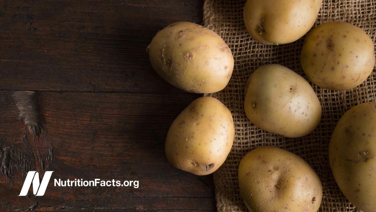 Fresh white potatoes on an old wooden table