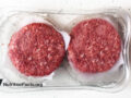 burger meat packaged in plastic on white stone counter