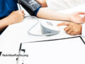 doctor measuring blood pressure and pulse with clip board