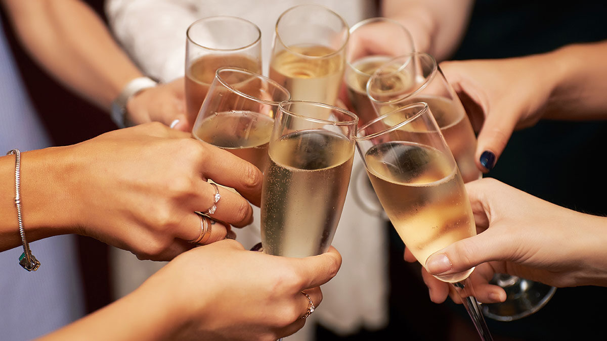 circle of people holding glasses of champagne