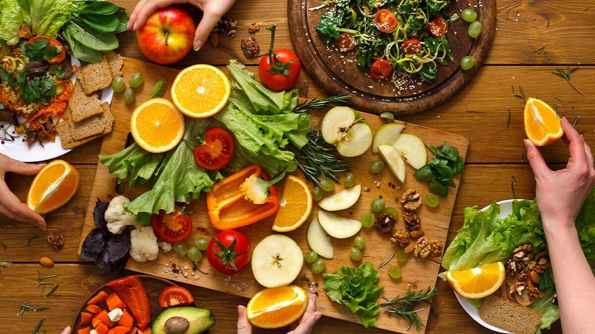 table laid out with various fruits, vegetables, and herbs