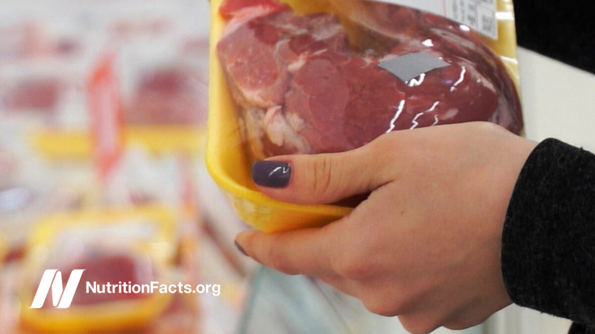 woman buying packaged meat in supermarket