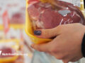 woman buying packaged meat in supermarket