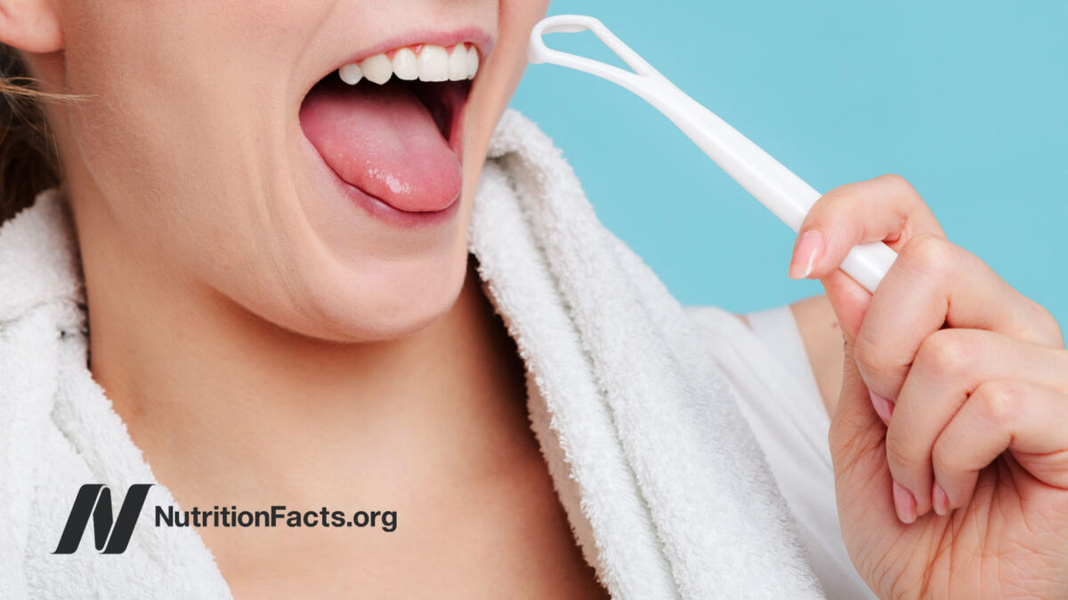 person holding a tongue scraper