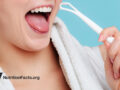 person holding a tongue scraper