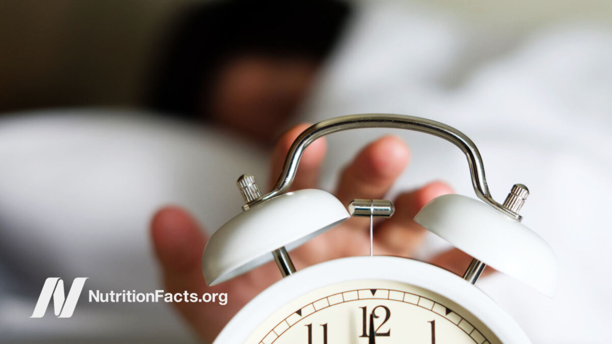 Hand reaching for the stopper on an alarm clock